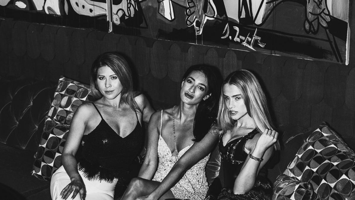 Gorgeous ladies sitting on velvet couches at Chicago's hottest cocktail lounge